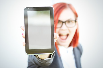 Business concept of success and negotiation. A woman boss, in a suit and glasses, emotionally shows the tablet. With a place for advertising text. Chef Day, Boss Day