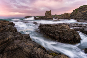 Flowing waves with colourful sunset sky at Cathedral Rocks, Kiama, Australia