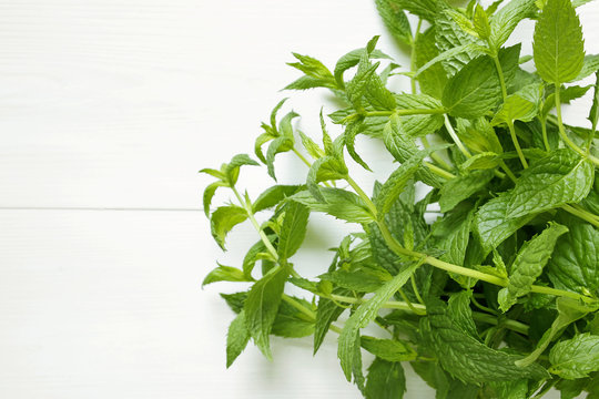bunch of fresh green mint on white wooden background