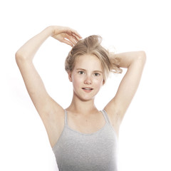 Fototapeta premium young teen girl holds blond hair up against white background