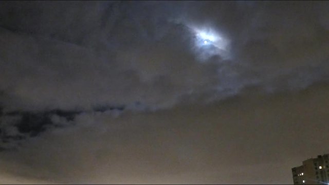 moon among the clouds over the city timelapse