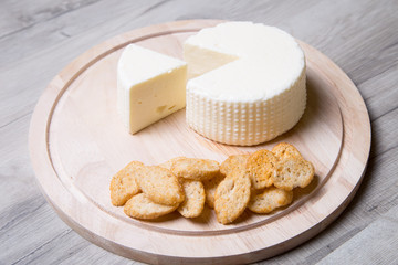 Tzfat cheese with crackers. Israeli traditional cheese. Symbol of the Jewish holiday Shavuot. Selective focus.