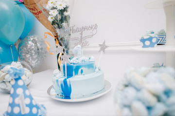 торт, букеты и бумажный колпак на фоне стены и воздушных шариков 