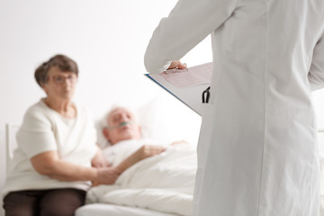 Obraz premium Elderly couple talking with doctor