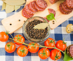 Black peppercorns and cherry tomatoes on the kitchen table