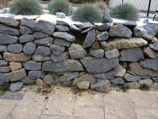 Broken stone wall in garden - 163465370