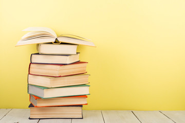 education and wisdom concept - open book on wooden table, color background