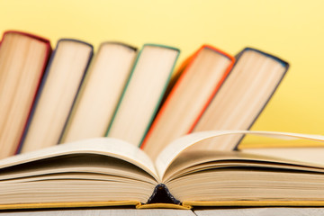 education and wisdom concept - open book on wooden table, color background