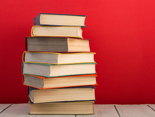 education and wisdom concept - books on wooden table, color background