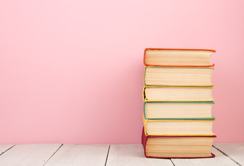 education and wisdom concept - books on wooden table, color background