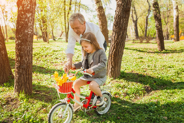Grandfather with girl riding bicycle