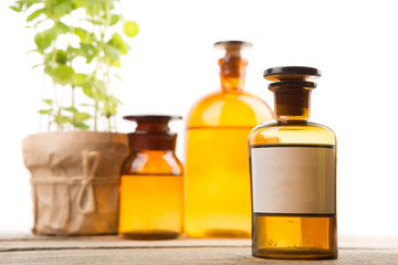 Pharmacy container with blank label and vintage medical bottles on the background