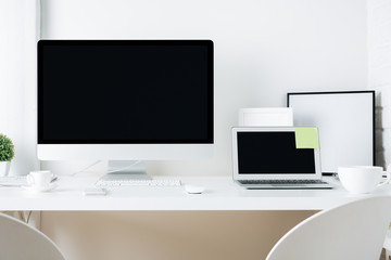White designer desktop with pc and laptop