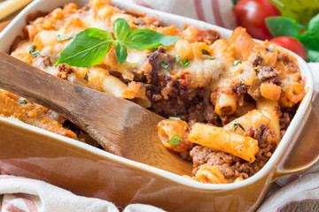 Ziti bolognese in baking dish. Pasta casserole with minced meat, tomato sauce and cheese, horizontal