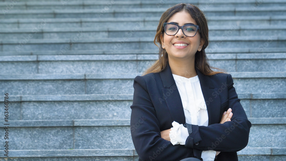 Wall mural portrait of young beautiful business woman (student) in suit, glasses, smiling, happy, walking down 