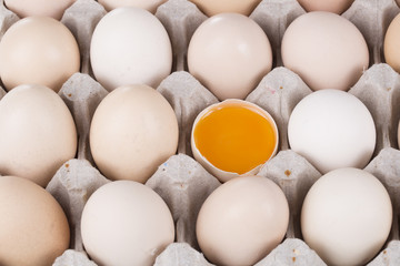 Box filled with eggs, with one broken egg 