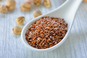 Flax seeds in spoon on table