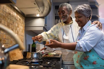 Crédence de cuisine en verre imprimé Cuisinier Souriant couple de personnes âgées préparant la nourriture dans la cuisine
