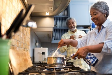 Smiling couple preparing food in kitchen