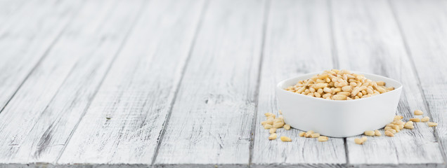 Wooden table with Pine Nuts (selective focus)