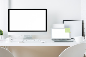 White designer desktop with computer and laptop
