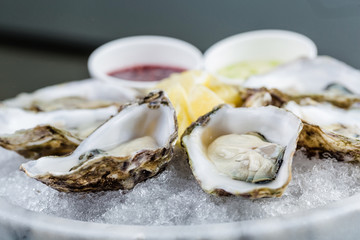 Fresh oysters platter with sauce and lemon