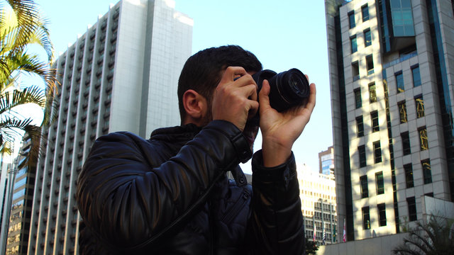 Young man photographing Paulista Avenue - Sao Paulo city, Brazil