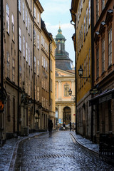 Stockholm, Sweden - May 31, 2017: A tourist walking along the old street of Stockholm after a rain