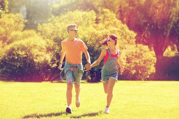 happy teenage couple running at summer park