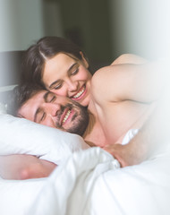 The happy man and woman relax on the bed