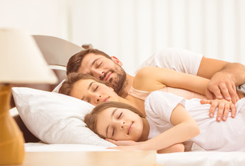 Obraz na płótnie Canvas The family sleeping in the bed. full grip focus