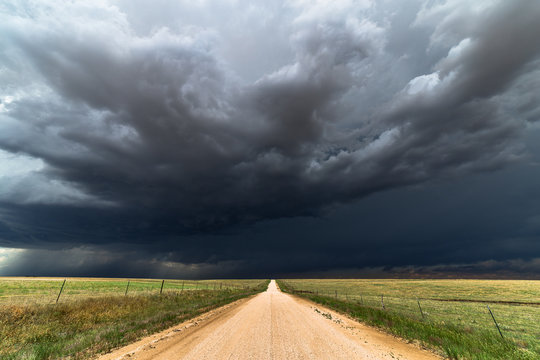 Dirt road with dark storm clouds