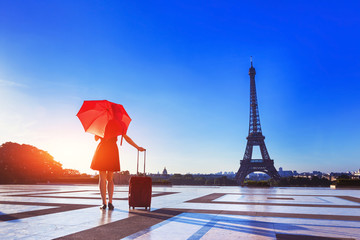 Girl with stylish red clothes, umbrella, suitcase, Eiffel Tower, fashion