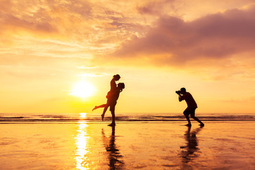 Photographer photographing a loving couple on the beach in summer