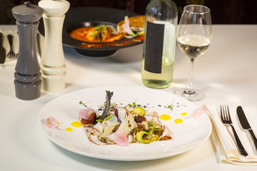 Salad from avocado with octopus and parmesan cheese.