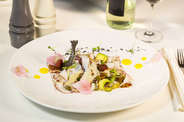 Salad from avocado with octopus and parmesan cheese.