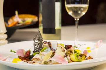 Salad from avocado with octopus and parmesan cheese.