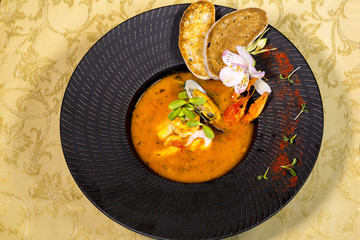 Seafood soup. Soup from salmon, pike perch, shrimp, octopus and mussels with croutons