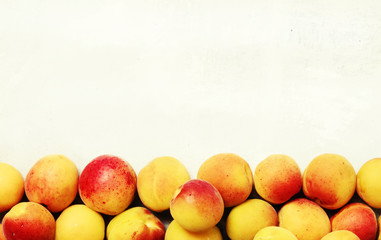 Summer white food background, fresh orange pink apricots, top view