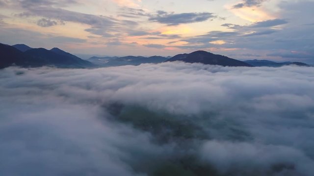 Aerial time lapse flight above mist clouds over beautiful evening nature colors hyperlapse