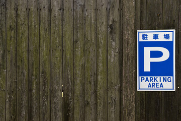 New parking lot sign on the old wooden wall.
