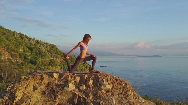 Young Slim Concentrated Girl Does Asanas on Large Stone