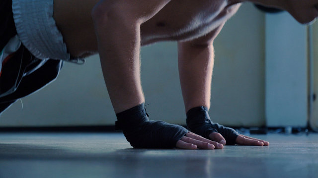 Professional boxer, do push-ups, in a good body, elastic bandages, punches bag. Concept: to love sports, training, endurance, willpower, technique, strategy, defense, stance, muscles, reaction