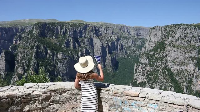 little girl waves with a Greek flag on Vikos gorge Zagoria