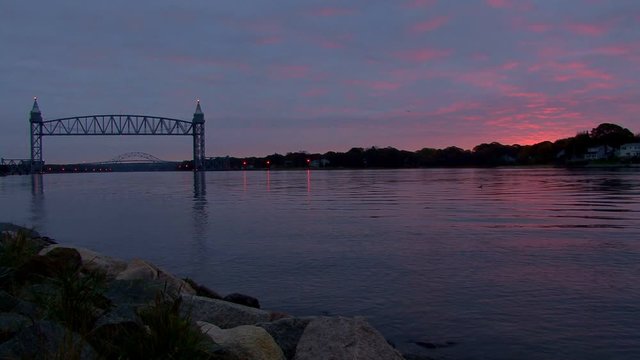 A sailboat quietly motors by in the cape cod canal at dawn heading out to sea