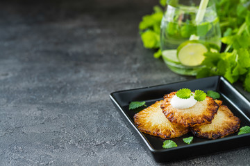 Fried pineapple slices with creme fraiche, dark background. Copy space
