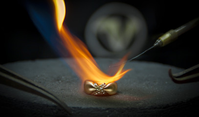 The jeweler solder the ring. - obrazy, fototapety, plakaty