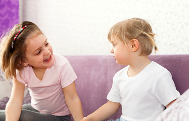 Two sisters sitting on   couch.