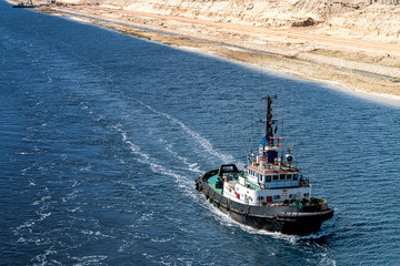 Schlepper fährt im neuen Erweiterungsabschnitt des Suezkanals