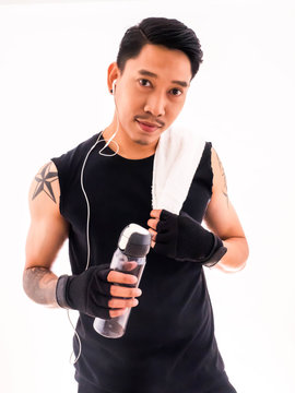 Handsome fit man holding a towel and a bottle of water with happy fitness.